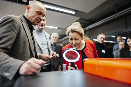 Roland Sillmann und Franziska Giffey stehen vor einem volumetrischen 3D-Drucker